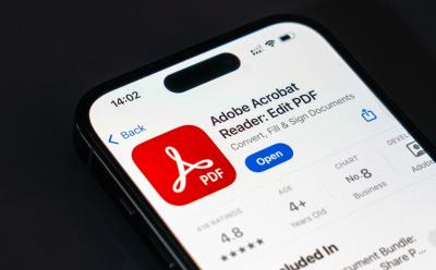 closeup shot of an iPhone previewing the Adobe Acrobat app's landing page on the App Store